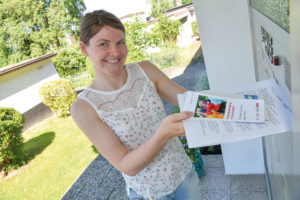 „Treffpunkt Bewegung – in Ihrem Stadtteil“ geht wieder los: Die 28-jährige Übungsleiterin Lisa Claussen aus Niederzwehren verteilt Flyer an die Teilnehmenden. Foto: © Stadt Kassel/Fotograf Harry Soremski